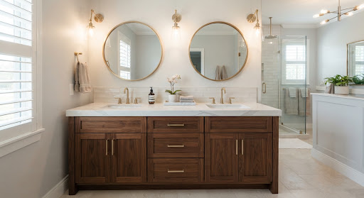 Double vanity design with walnut cabinetry, white quartz counter, undermount sinks, round mirrors, and wall sconces.